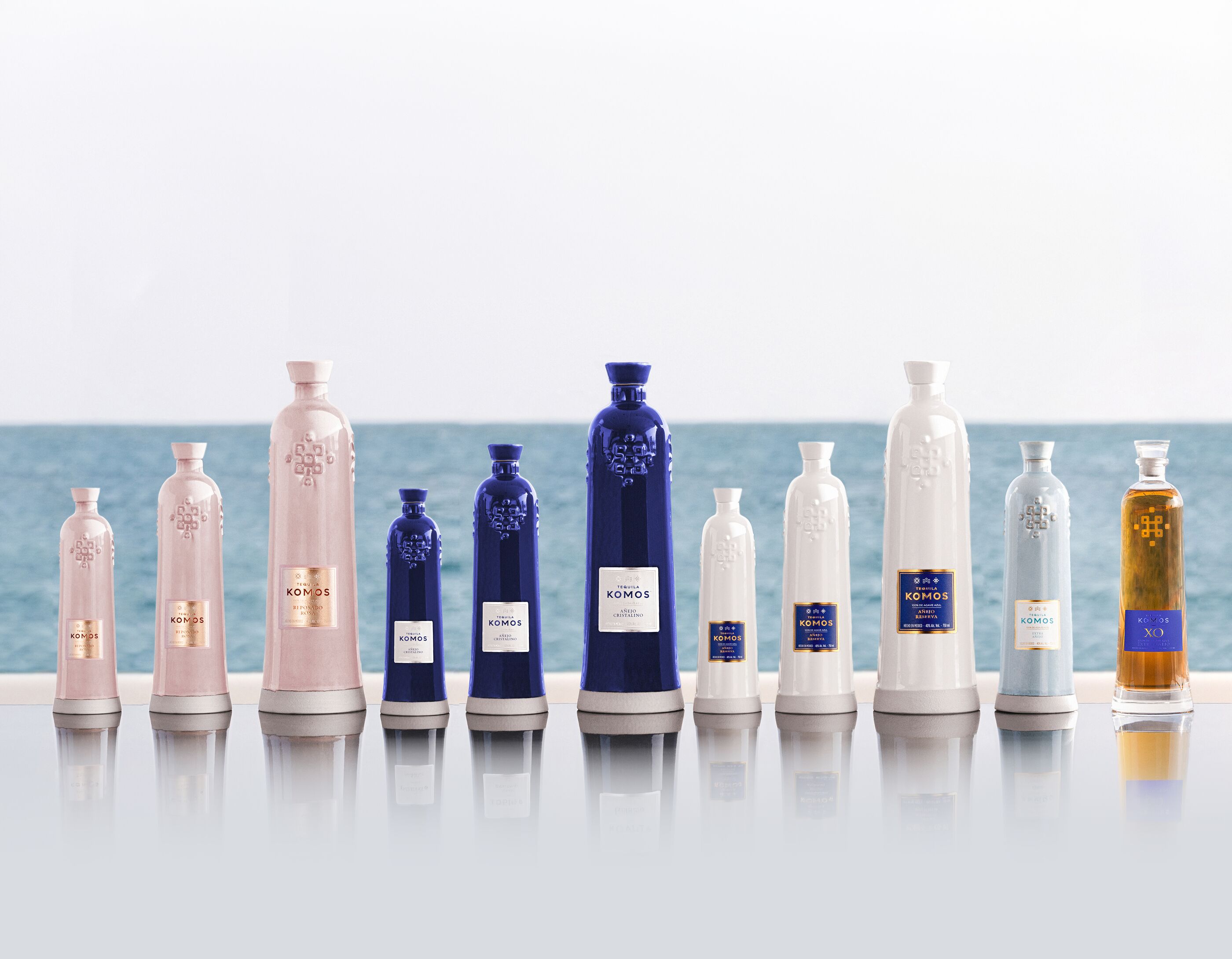 The Komos range of ceramic bottles lined up by the sea